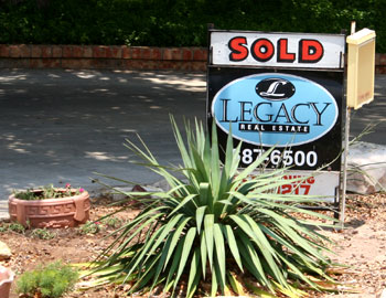 Photo of the 'Sold' sign in our front yard