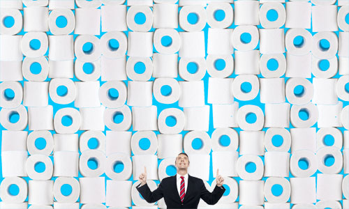 Man standing in front of a mountain of toilet paper