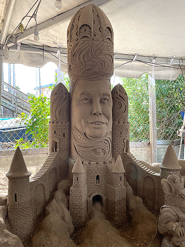 Photo - Sand sculpture of Elon Musk's head on a rocket