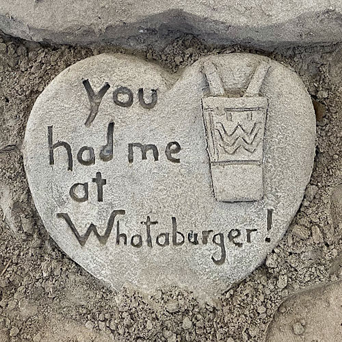Photo of a heart-shaped sand sculpture reading 'You had me at Whataburger'
