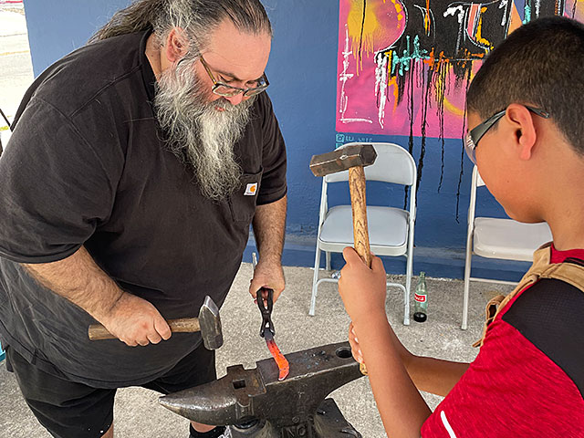 Photo: Knife-making lesson taking place in front of Caylor Forge