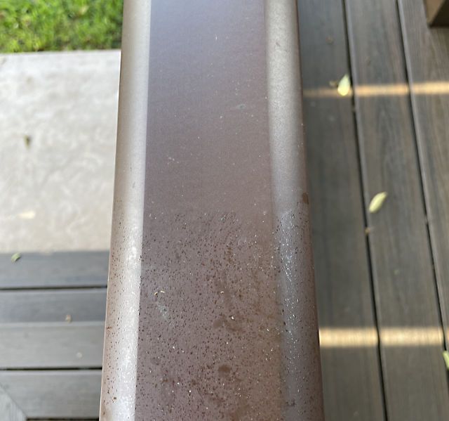 Photo: Section of deck railing showing before and after cleaning of aphid honeydew